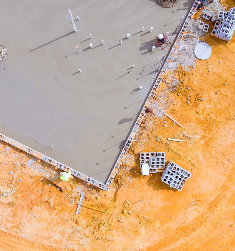 After concrete is poured on wet foundation, mason polishes concrete using concrete polishing machine.